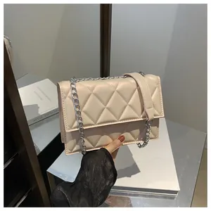 Detail of beige quilted leather shoulder bag with silver chain strap and flap closure