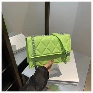 Detail of lime green quilted handbag featuring a silver chain strap and leather stitching