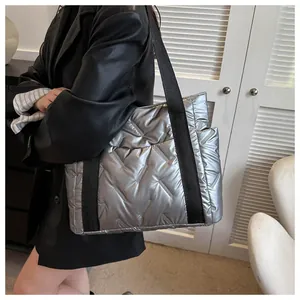 Silberne gesteppte Tragetasche im Metallic-Look mit schwarzen Trägern am Model