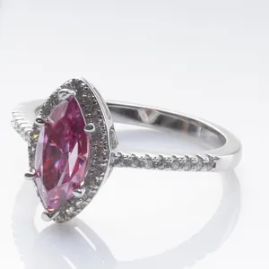 Detalle de anillo de moissanita rosa talla marquesa con halo y acentos en banda de plata