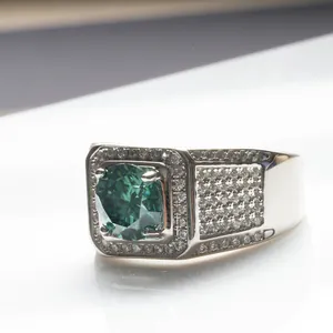 Vue rapprochée d'une bague émeraude taille coussin avec diamants pavés sur anneau argent