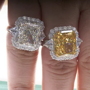 Close-up of luxury radiant cut yellow and white carbon diamond halo rings on finger