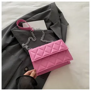 Close-up of pink quilted leather texture and silver chain strap on a stylish crossbody bag