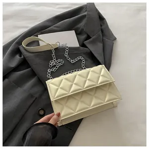 Detailed macro view of cream quilted PU leather bag with elegant silver metal chain