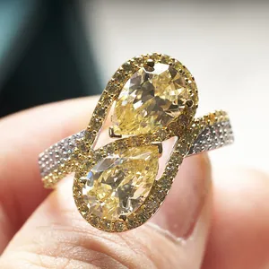 Macro view of twin pear-cut yellow stones and pavé accents on a S925 silver ring