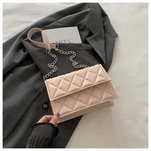 Detail of pink quilted texture and metal chain strap on a faux leather crossbody bag