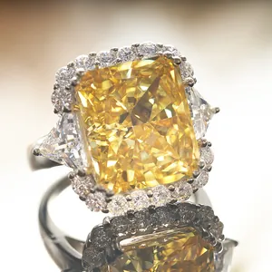 Macro shot of Radiant-cut yellow diamond ring with triangular side stones and pavé halo