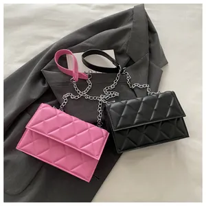 Close-up of pink and black quilted crossbody bags with silver metal chain straps