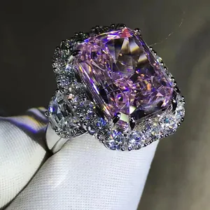 Macro view of radiant cut pink carbon diamond ring with double halo and side stones