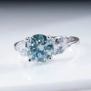Macro d'une bague en argent 925 avec pierre ronde bleue et pierres latérales en poire