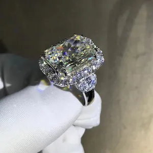 Macro shot of 10-carat radiant cut yellow gem ring with halo setting on white gloves