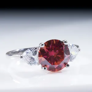 Vue macro d'une bague en argent à trois pierres avec gemme rouge et accents poire