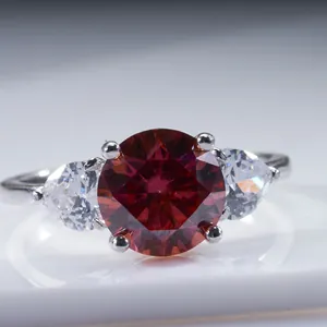 Macro d'une bague en argent avec une grande pierre rouge et des pierres latérales