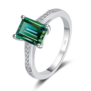 925 silver ring featuring emerald cut green moissanite and side stones on white background