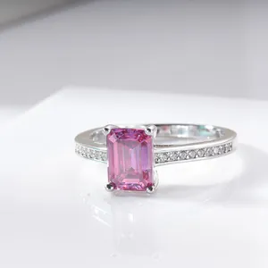 Macro view of radiant emerald-cut pink stone and side diamonds on silver band