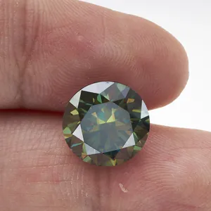 Moissanite vert foncé taille brillant tenue entre les doigts sur fond blanc épuré