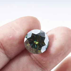 Moissanite vert foncé à taille brillant ronde tenue par les doigts montrant l'éclat