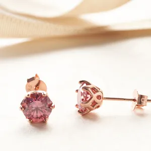 Detailed close-up of pink moissanite stud earrings with rose gold S925 silver hallmarks