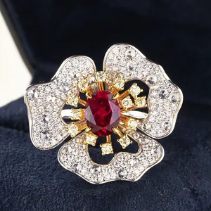 Macro shot of a floral ring featuring an oval ruby center and white diamond-set petals
