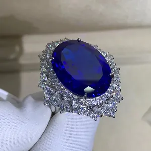 Dettaglio macro di anello con zaffiro blu ovale 30ct e halo floreale lucido in argento