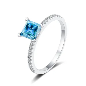 Detailopname van een prinsesgeslepen blauwe edelsteenring met micro-pavé diamanten