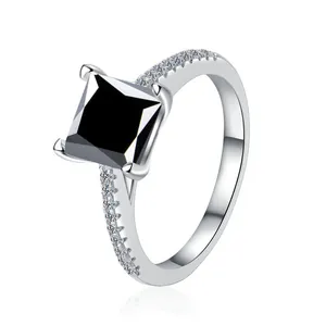 Vista macro di anello con pietra nera taglio princess e diamanti pavé su fascia argento