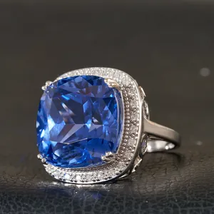 Anillo de oro blanco 18K con zafiro cojín de 30ct y halo de diamantes sobre cuero