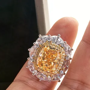 Luxurious 8-carat yellow cushion cut diamond ring with marquise halo on finger