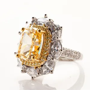 Macro shot of yellow cushion cut diamond ring with marquise halo on white background