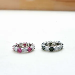 Dettaglio di anelli in argento S925 moissanite con grappoli di pietre rosa e verdi