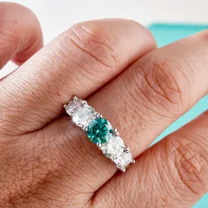 S925 zilveren ring met een groene moissaniet in het midden en heldere accentstenen