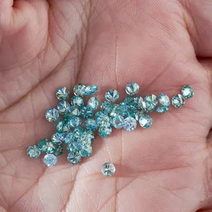 Macro-opname van 3 mm blauwe ronde briljant geslepen moissanite stenen op een palm