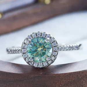 Classic silver ring featuring a round green moissanite with a halo setting and side stones
