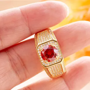 Macro detail of gold ring with large red round center stone and pave zircon accents