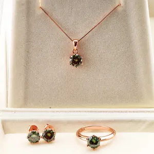Detalle macro del conjunto de joyas de plata S925 con piedras verdes y baño de oro rosa