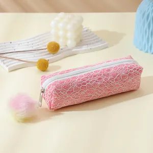 Détail de la trousse rose pailletée avec dentelle et pendentif pompon moelleux