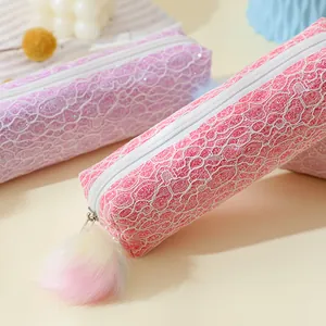 Gros plan de trousses à paillettes roses et mauves avec dentelle et pompons arc-en-ciel