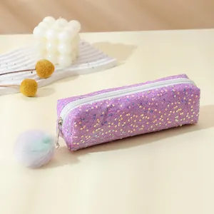 Detail of purple sequin pencil case with white zipper and a fluffy rainbow pompom charm
