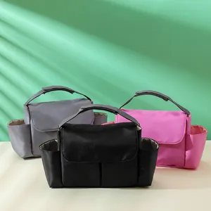 Portable stroller organizer bags in grey, black, and pink with large main compartments