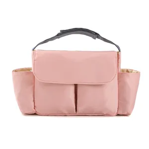 Pink multi-functional diaper organizer with side pockets and gray webbing handles