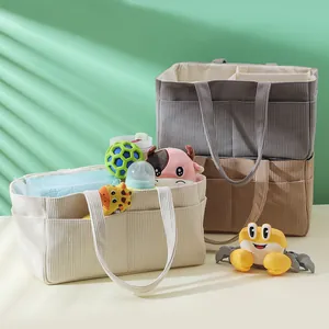 Corduroy diaper bag detail showing internal compartments and side pockets for baby items