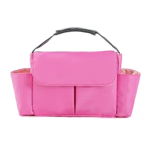 Pink multipurpose nursery storage bag with gray woven handles and side pockets