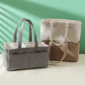 Detailed close-up of corduroy organizer bags in gray, beige, and brown with multiple pockets