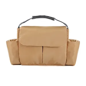 Detail view of khaki diaper bag with side pockets and top handle for strollers