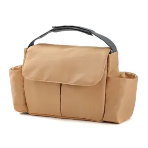 Detail of khaki foldable diaper bag showing main compartment and side bottle pockets