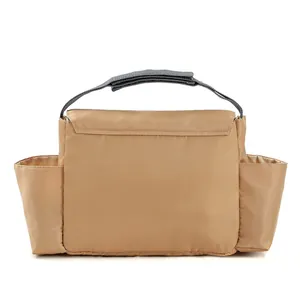 Macro detail of multi-compartment khaki diaper bag with side pockets and gray handles