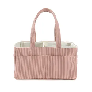 Pink corduroy diaper organizer bag featuring internal white dividers and carry handles