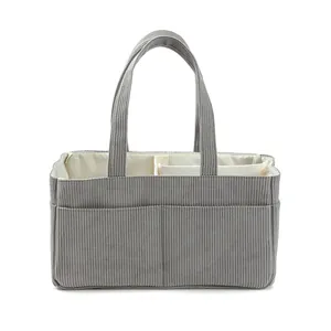 Detail view of corduroy diaper bag with internal dividers and striped texture