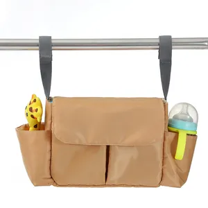 Detail view of khaki stroller organizer bag showing pockets and velcro straps