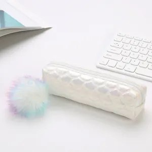 Estuche blanco iridiscente con escamas de pez y un pompón de peluche colorido